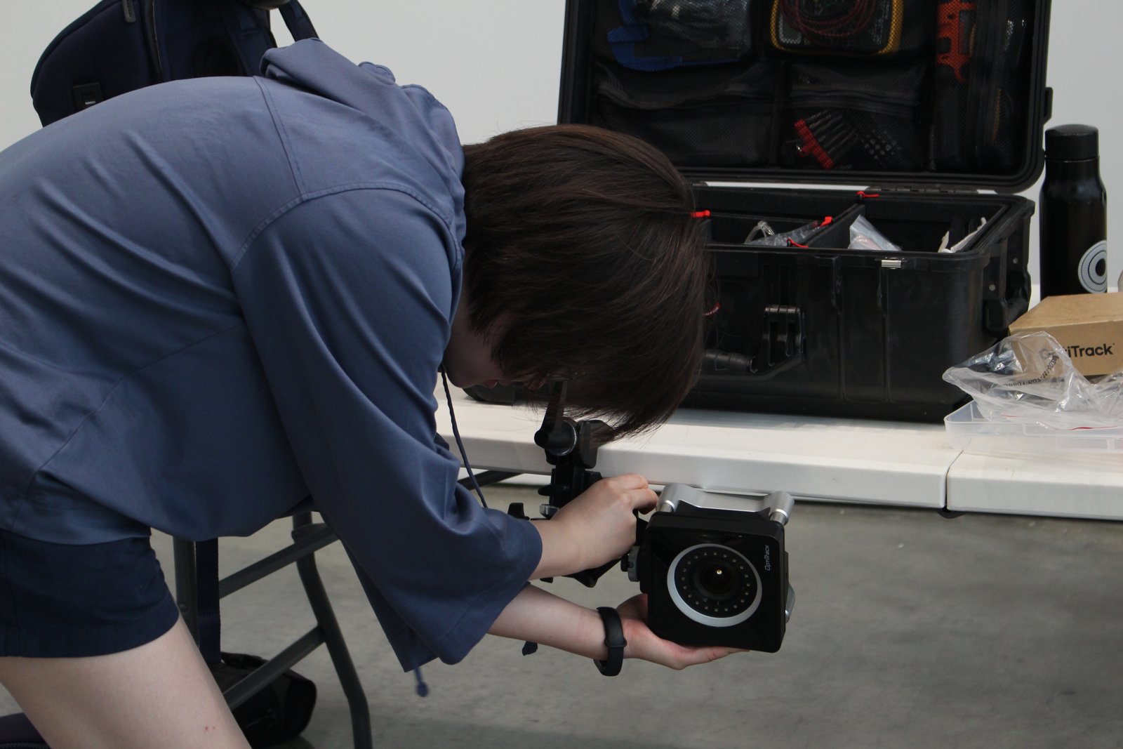 A technician mounting and aiming an OptiTrack camera during setup