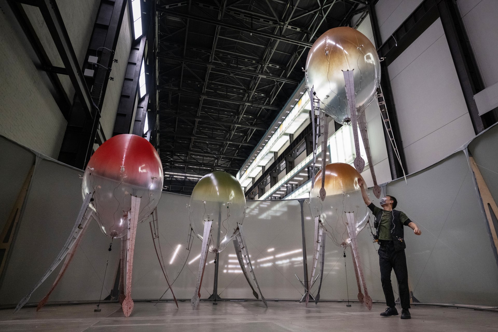 Eight aerobes in flight above visitors gathered on the Turbine Hall bridge
